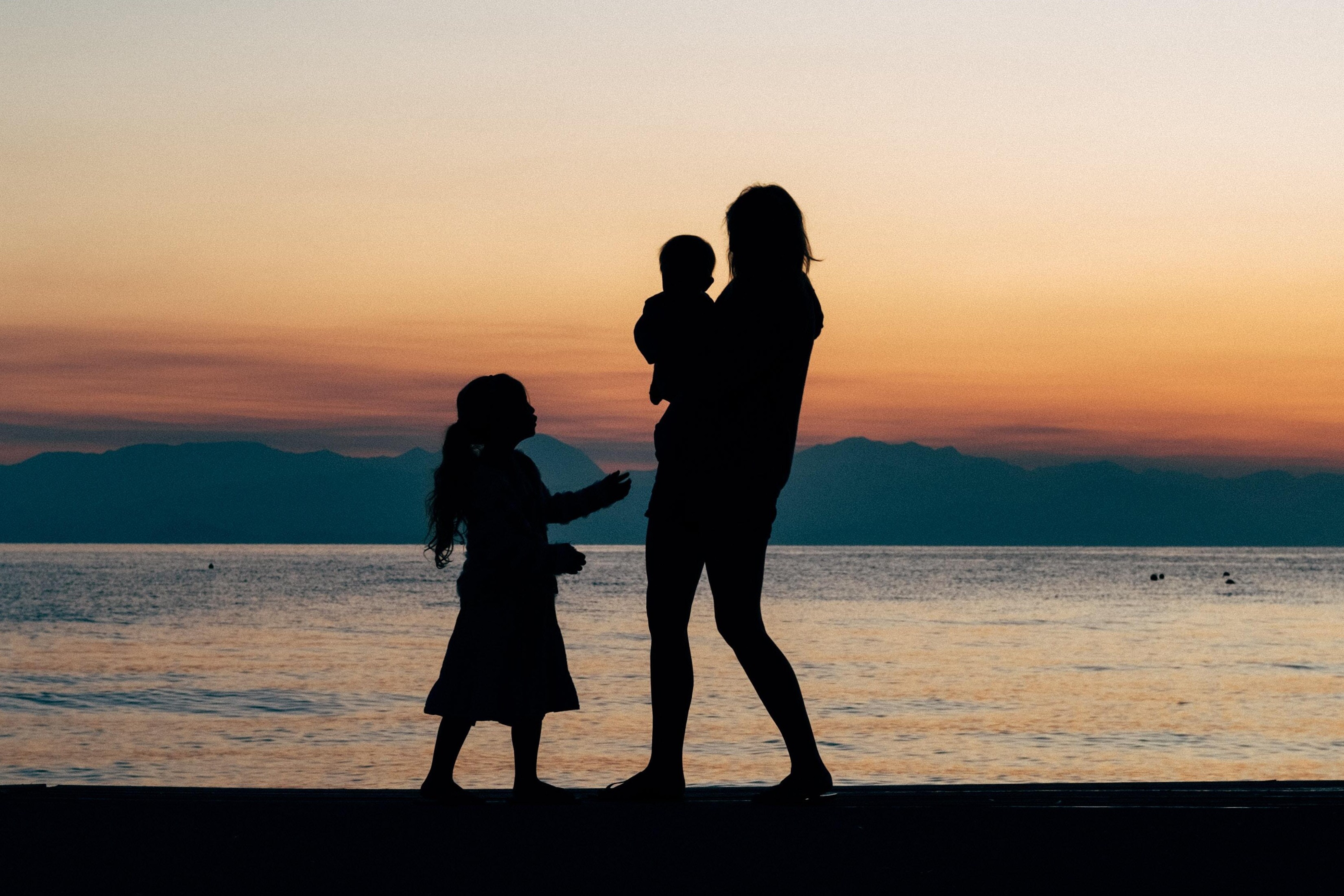 silhouette of a family walking on the beach at sunset