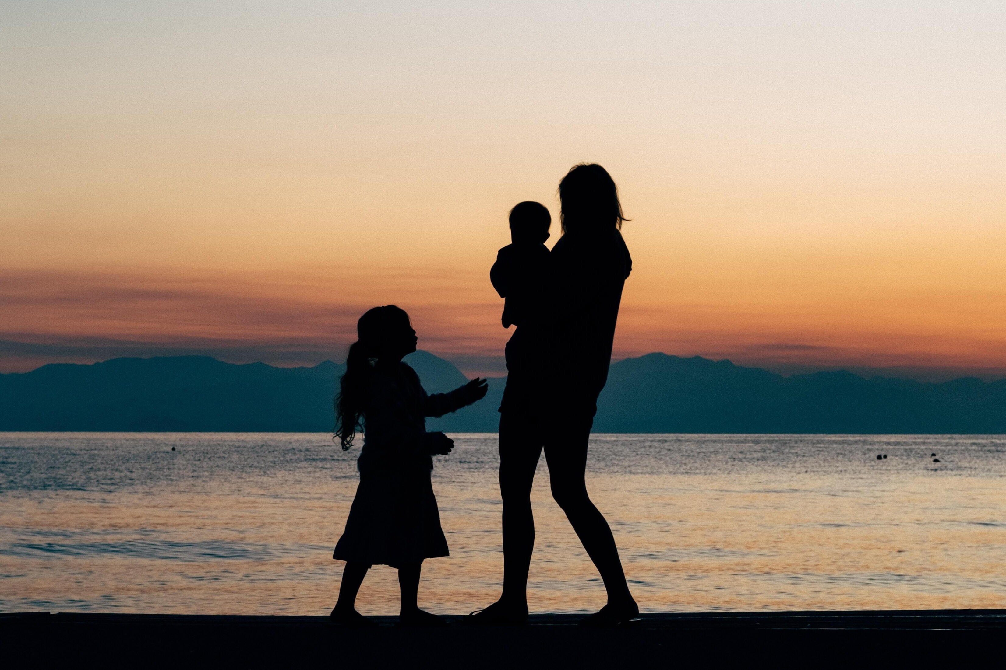 Silhouette of a family walking on the beach at sunset